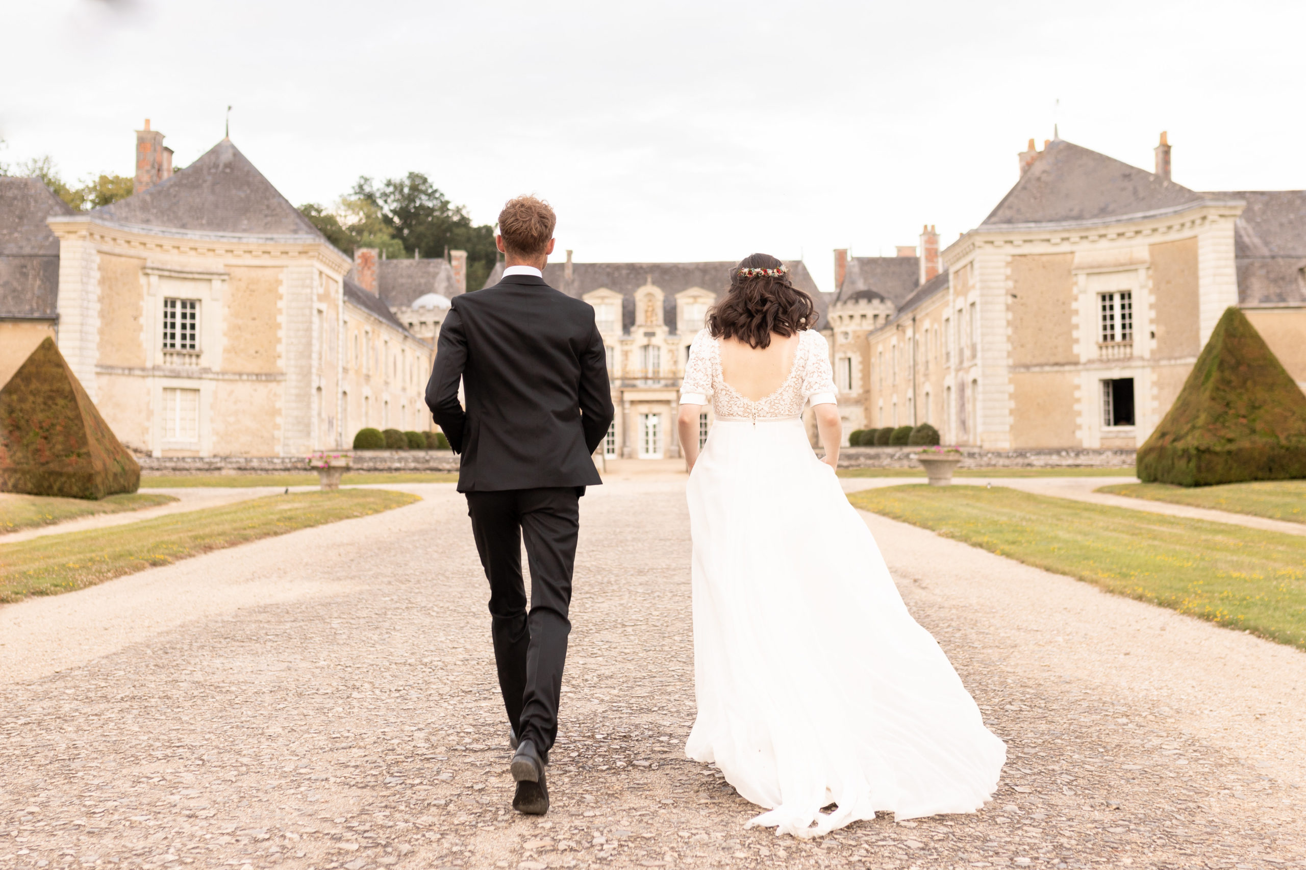 château location mariage. proche d'Angers, château de la Lorie à Segré en Anjou Bleu, couple de mariés marchant vers château pour réception mariage